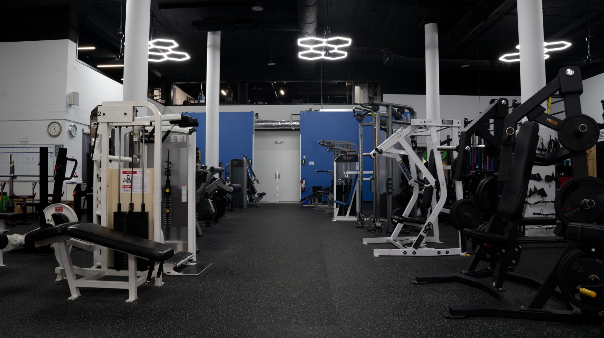 The downtown Kings Fitness floor under hexagonal lights